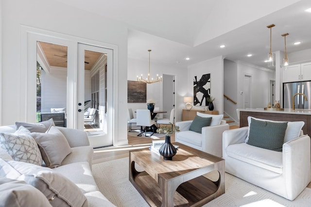 living room featuring vaulted ceiling, light wood-type flooring, and a chandelier