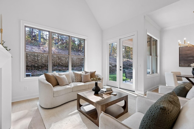 living room featuring french doors, high vaulted ceiling, and a notable chandelier