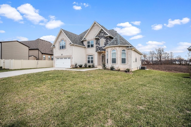 view of front of property featuring a front yard, a garage, and central AC unit