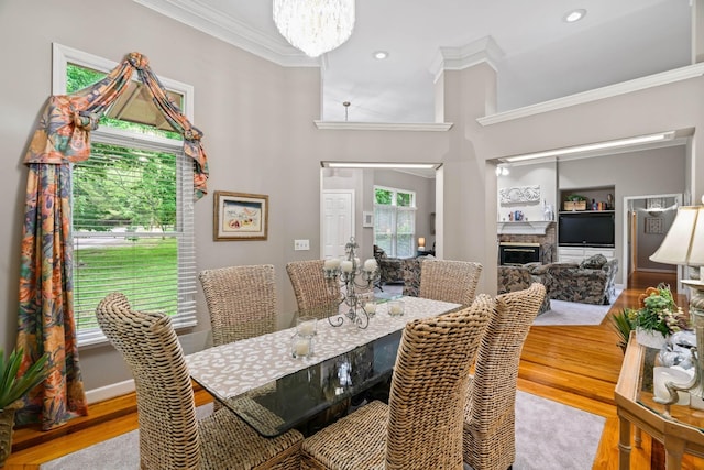 dining area featuring an inviting chandelier, ornamental molding, and light hardwood / wood-style flooring