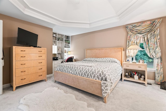 carpeted bedroom featuring a tray ceiling and crown molding