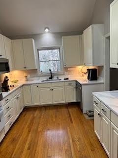 kitchen with sink, white cabinets, light wood-type flooring, and electric stovetop