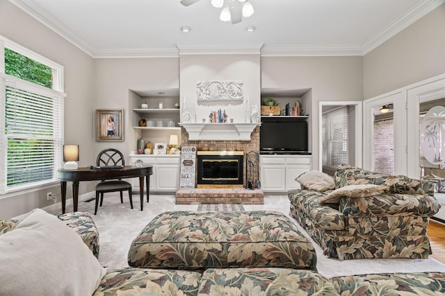 living room with built in shelves, ceiling fan, a fireplace, and ornamental molding