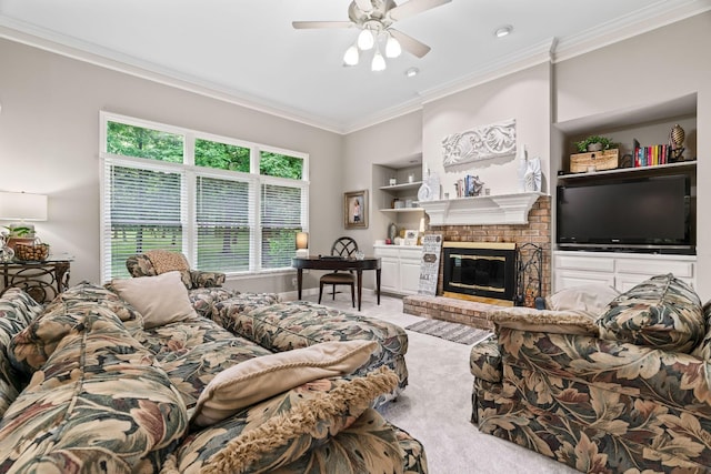 carpeted living room featuring built in shelves, a brick fireplace, ceiling fan, and crown molding