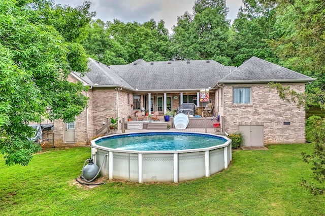 view of pool with a deck and a yard