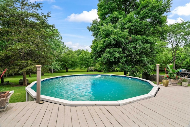 view of swimming pool with a lawn and a wooden deck