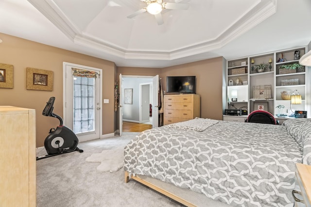 bedroom with crown molding, ceiling fan, access to exterior, a tray ceiling, and carpet floors