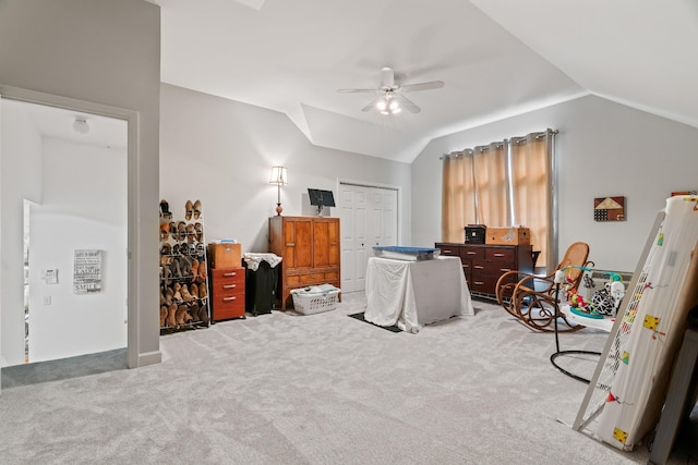 bedroom featuring ceiling fan, a closet, light colored carpet, and vaulted ceiling