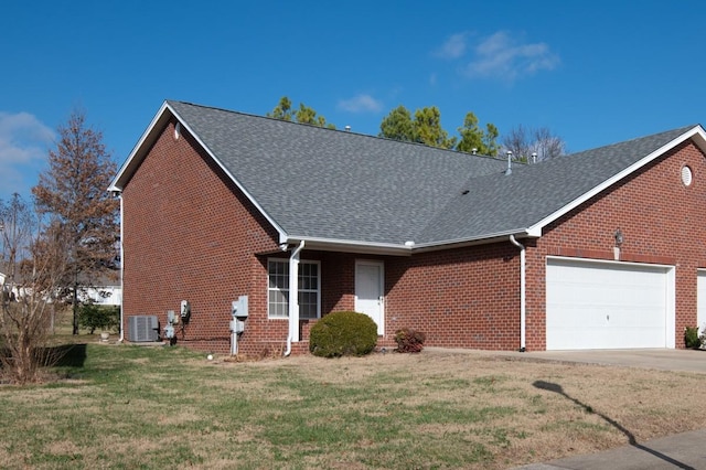 ranch-style home featuring a front lawn, a garage, and central AC unit