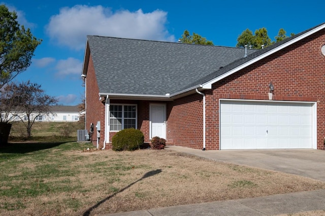 view of front of home featuring central AC unit, a front lawn, and a garage