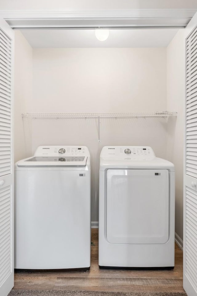 washroom featuring washing machine and clothes dryer and hardwood / wood-style flooring