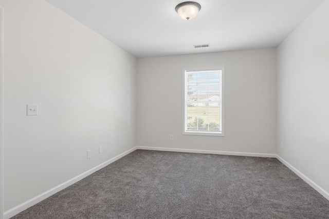 unfurnished room with dark colored carpet