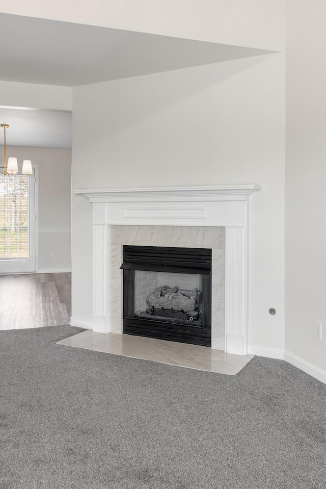 room details with a premium fireplace, carpet floors, and a notable chandelier