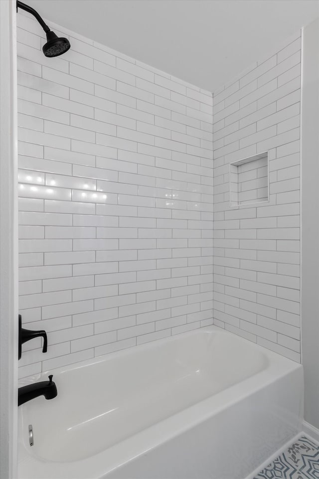 bathroom featuring tile patterned floors and tiled shower / bath combo