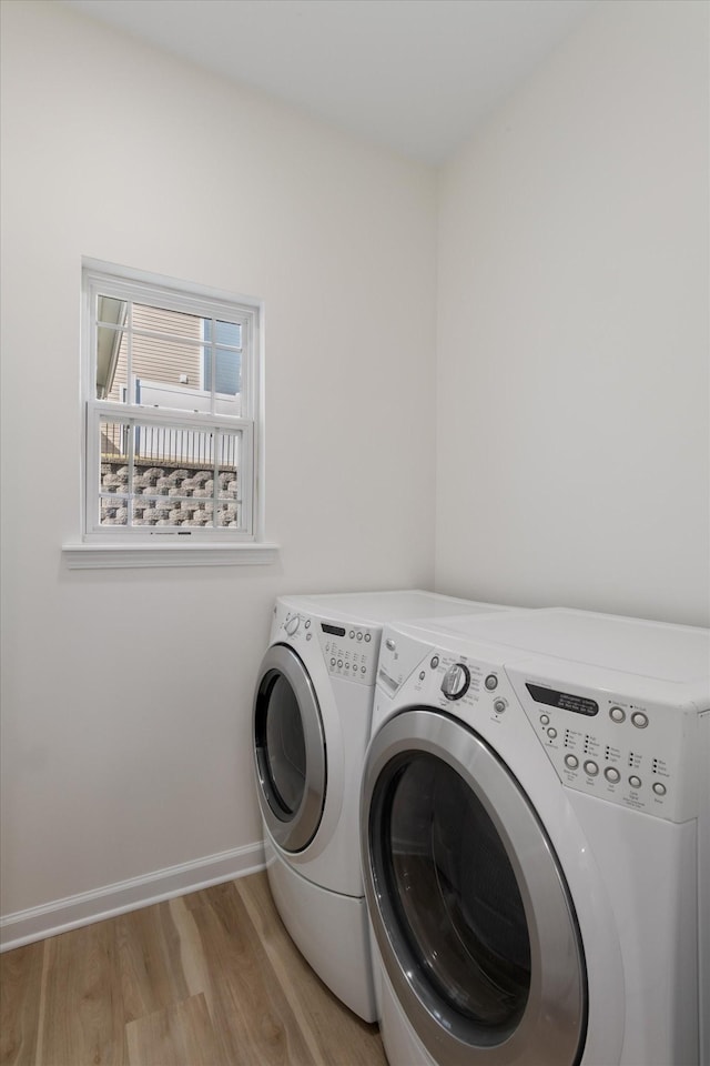 laundry area featuring separate washer and dryer and light hardwood / wood-style floors