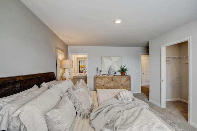 carpeted bedroom featuring a walk in closet and a closet