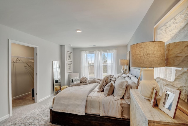 bedroom featuring a walk in closet, a closet, and carpet floors