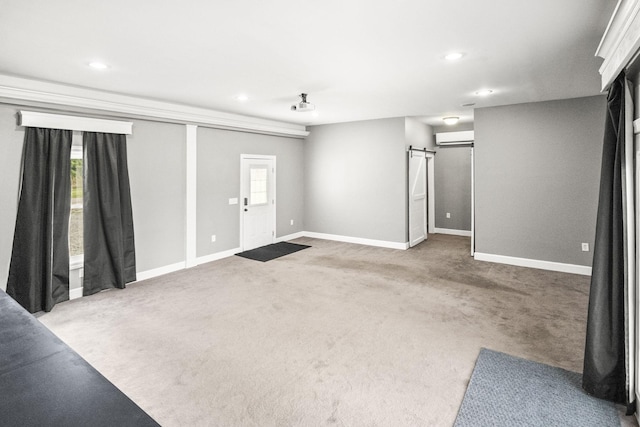 interior space with light carpet, a barn door, and an AC wall unit