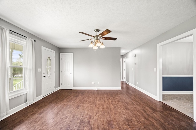 unfurnished room featuring ceiling fan, dark wood-type flooring, and a textured ceiling