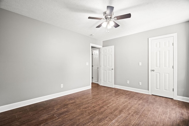 unfurnished bedroom with a textured ceiling, ceiling fan, and dark wood-type flooring