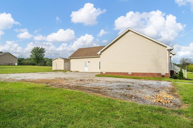 view of home's exterior with a lawn and a shed