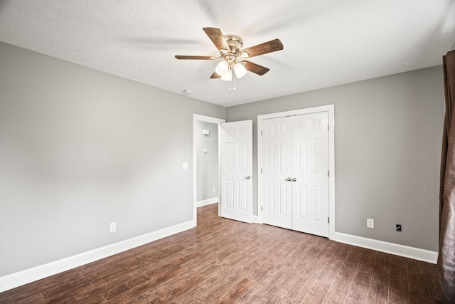 unfurnished bedroom with wood-type flooring, a textured ceiling, a closet, and ceiling fan