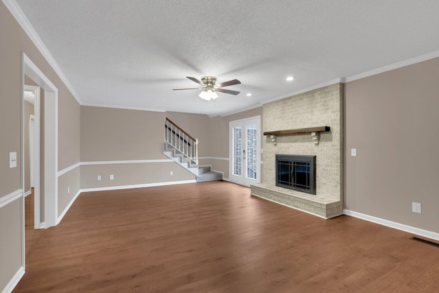 unfurnished living room featuring a fireplace, ceiling fan, wood-type flooring, and a textured ceiling