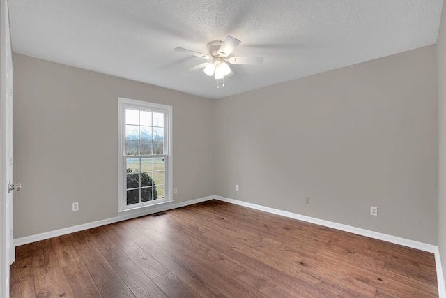 spare room with hardwood / wood-style floors, ceiling fan, and a textured ceiling