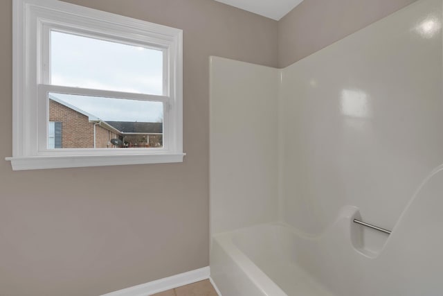 bathroom featuring washtub / shower combination and tile patterned floors