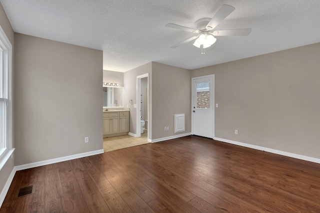 interior space with ceiling fan, light hardwood / wood-style flooring, and a textured ceiling