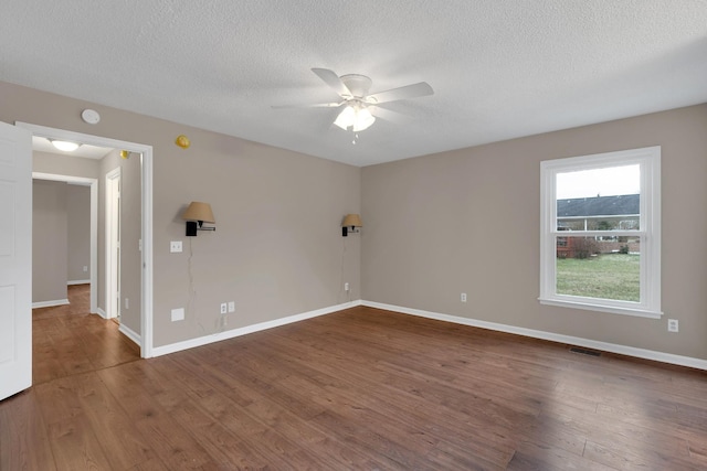 spare room with a textured ceiling, hardwood / wood-style flooring, and ceiling fan