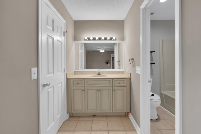 bathroom with a washtub, vanity, a textured ceiling, tile patterned flooring, and toilet