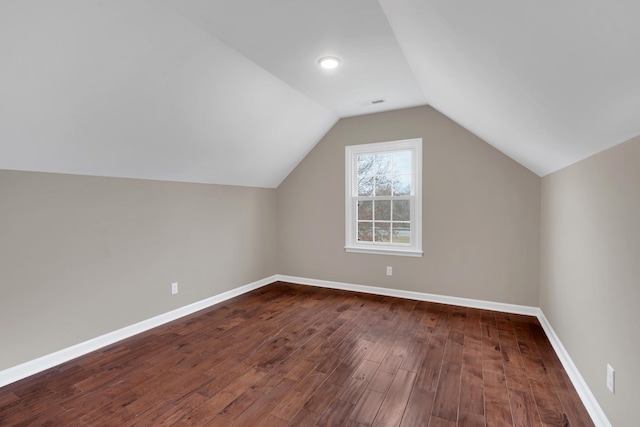 bonus room with dark wood-type flooring and vaulted ceiling