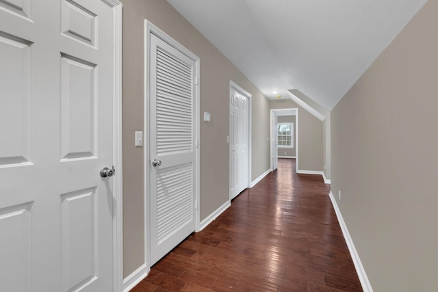 hall featuring vaulted ceiling and dark wood-type flooring