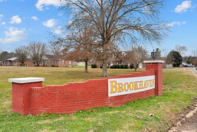 community / neighborhood sign featuring a lawn