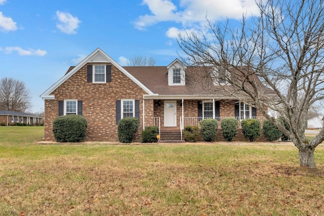 view of front of home featuring a porch, a front lawn, and brick siding