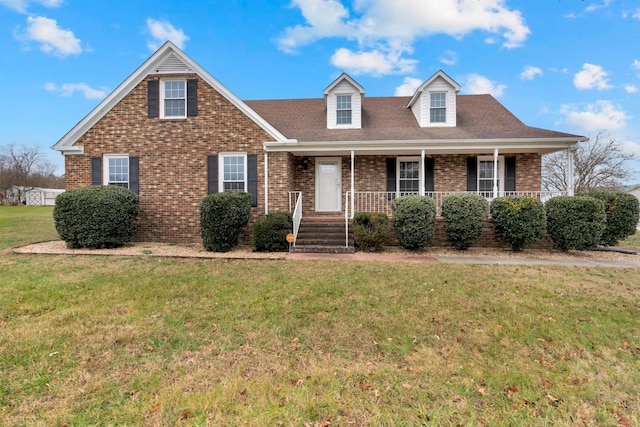 cape cod-style house with a porch, brick siding, and a front lawn