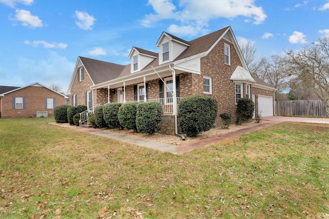 view of side of home with a lawn, a garage, and covered porch