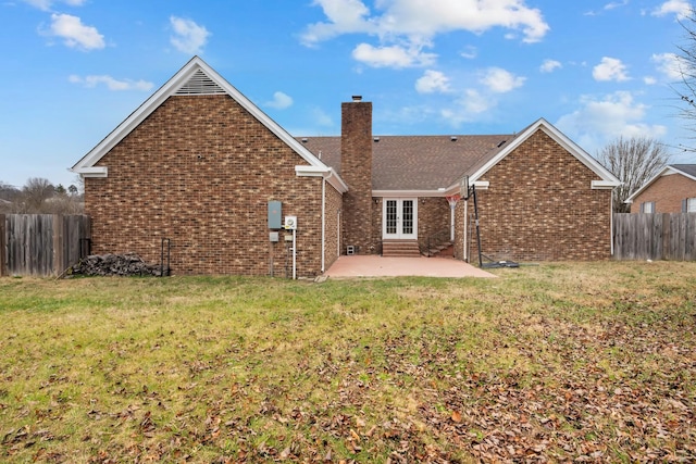 back of property with a lawn and a patio area