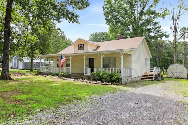 view of front of home featuring covered porch and a storage shed