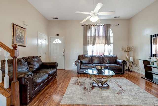 living room with ceiling fan and dark wood-type flooring