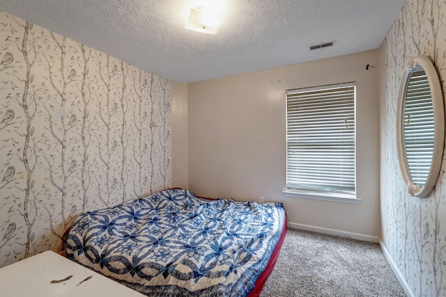 carpeted bedroom featuring a textured ceiling