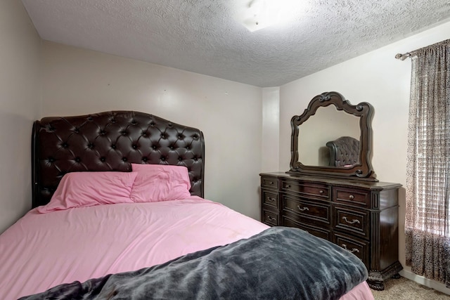 bedroom with light carpet and a textured ceiling