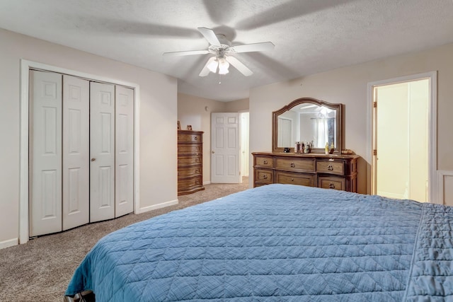 carpeted bedroom with ceiling fan, a closet, and a textured ceiling