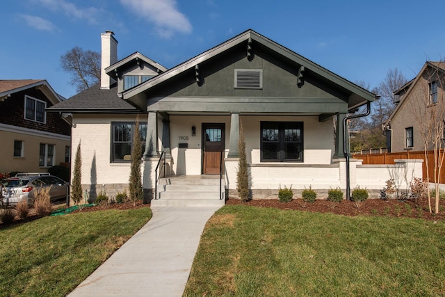 bungalow-style house featuring a front yard and covered porch