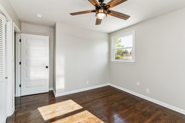 spare room featuring ceiling fan and dark wood-type flooring