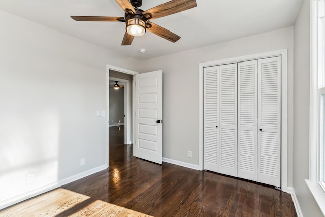 unfurnished bedroom with ceiling fan, a closet, and dark hardwood / wood-style floors