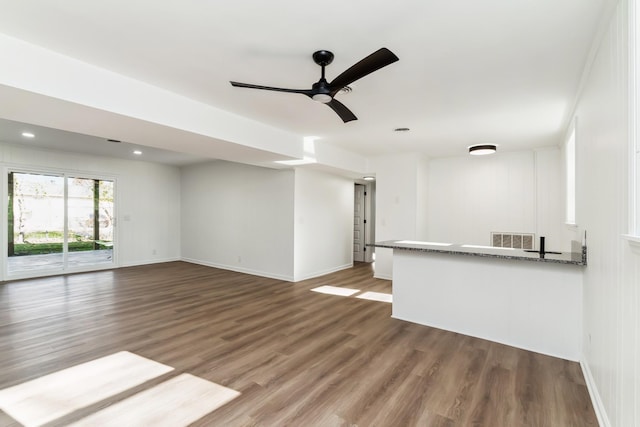 unfurnished living room with ceiling fan and dark wood-type flooring