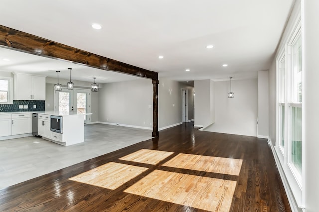 unfurnished living room featuring beamed ceiling, french doors, and hardwood / wood-style floors