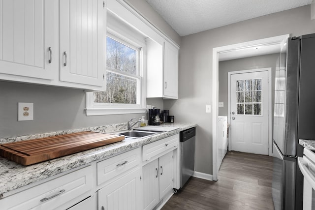 kitchen with sink, stainless steel appliances, white cabinetry, and a textured ceiling